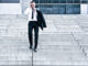 Corporate Man With Cellular Phone Descending On Company Stairs