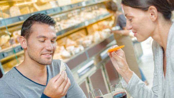 Couple having meal, looking at the cheese they are eating