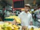 A handsome bearded man buys bananas in a supermarket