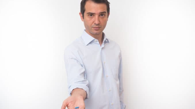 Man showing a bunch of medicine pills in his hand
