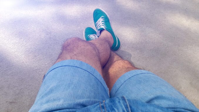 Man with hairy legs in denim shorts