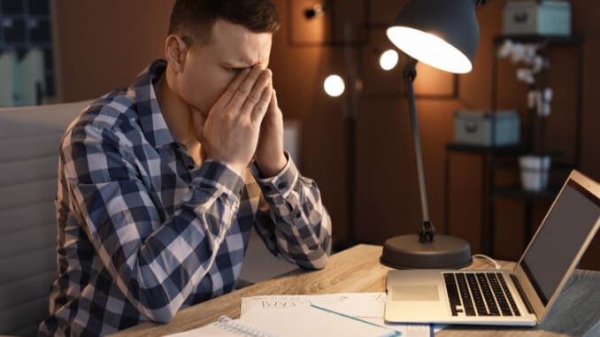 Overworked man with headache in office