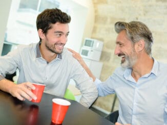 Men laughing and drinking coffee me