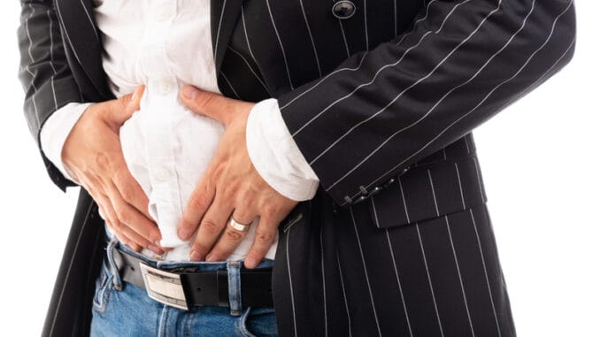 Close-up of business man showing stomach ache pain gesture isolated on white background