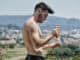 Shirtless Young Man Putting on Sunscreen Cream