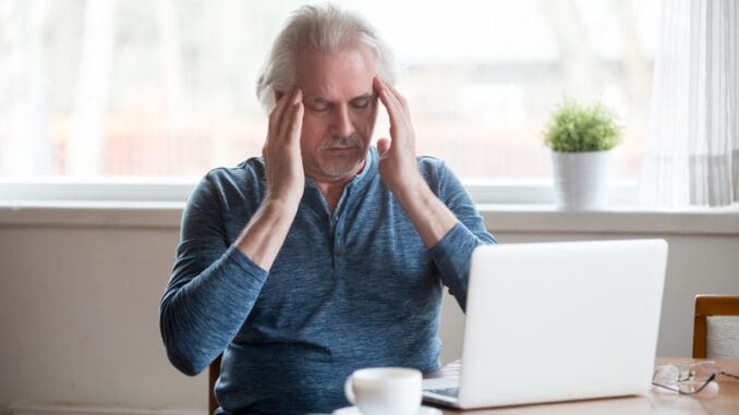 dreamstime_s_128054700 Tired fatigued middle aged senior man touching temples feeling headache migraine working on laptop at home, old elderly mature man trying to remember or focus suffering from memory loss disorder