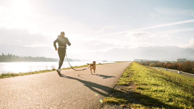 man jogging with his beagle dog