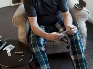 Close up shot of a diabetic man using an insulin pen at home