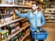 Man with thirst to alcohol taking beer from the shelves with strong drinks in the supermarket