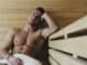 Happy good looking and attractive young man with muscular body relaxing in sauna hot