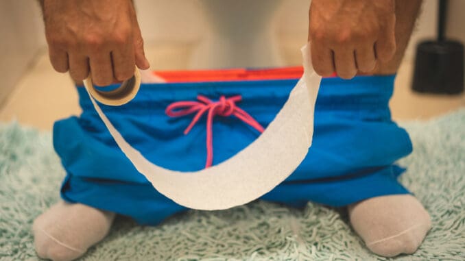 dreamstime_s_149578559 Man sitting in toilet and holds toilet paper roll diarrhea constipation