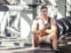 Portrait of confident athlete handsome masculine man sitting during treadmill exercise in gym