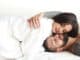 couple in love smiling while lying on bed together