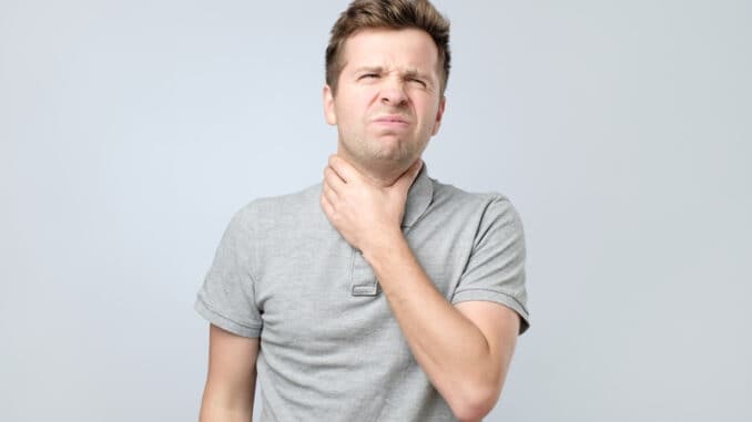 Young man with throat pain feeling ill.