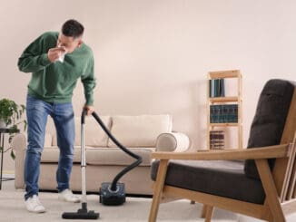 Man with dust allergy cleaning his home