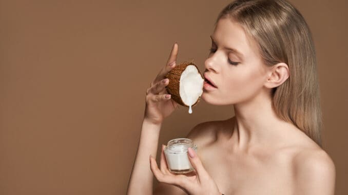 dreamstime_s_179358572 Beautiful young adult woman hold coconut in hand