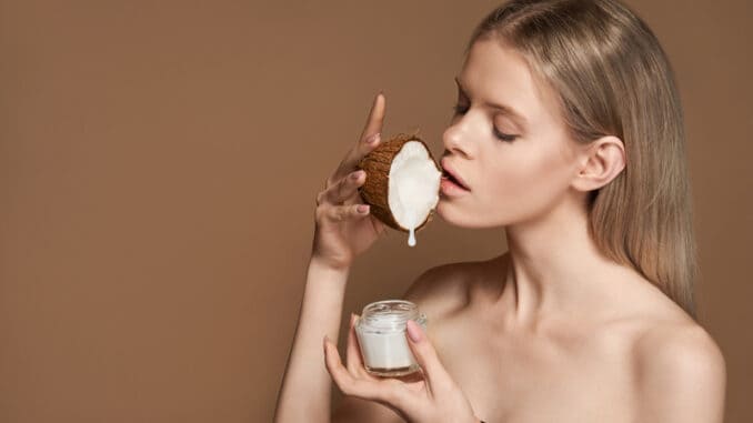 Beautiful young adult woman hold coconut in hand