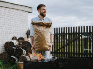 A man with a craft bag of charcoal in his hands.