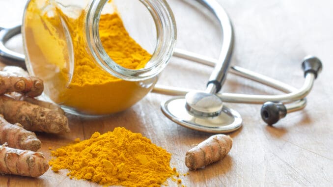 Turmeric powder and turmeric roots with stethoscope, natural medicine concept