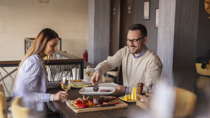 Beautiful couple on a date at restaurant, eating lunch and having fun