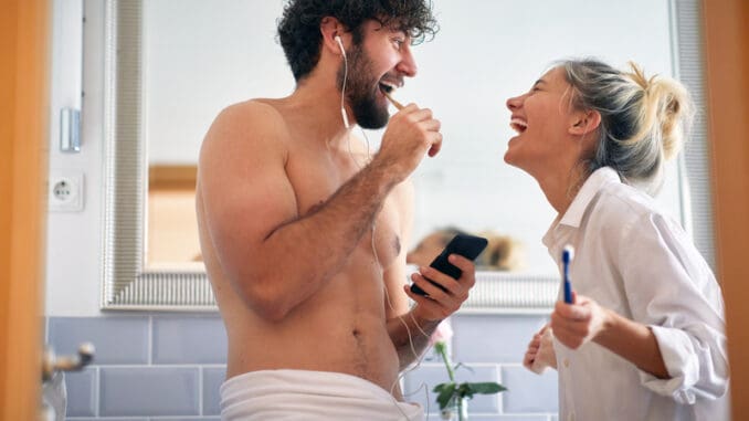 Sweet couple brushing teeth together in the morning