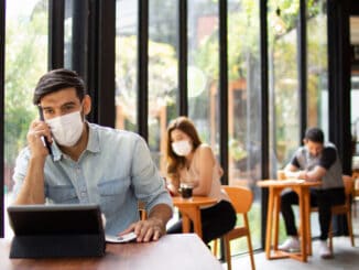 People wearing surgical masks are sitting in restaurants