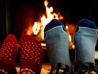 Feet in woolen socks in front of a warm fireplace on a cold winters evening.