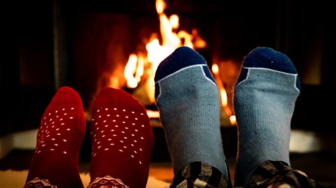 Feet in woolen socks in front of a warm fireplace on a cold winters evening.