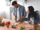 Couple preparing dinner together on home kitchen.