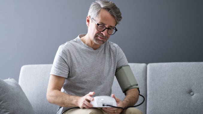 Elder Man Checking Blood Pressure At Home