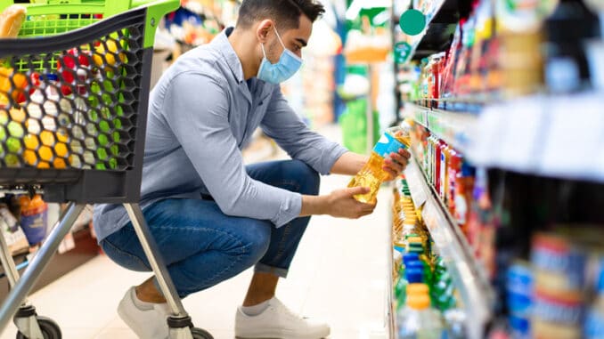 Middle-Eastern Man Doing Grocery Shopping Choosing Cooking Oil On Shelf In Supermarket.