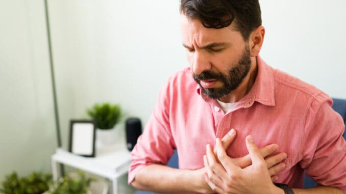 Handsome man in his 30s at home having a heart attack