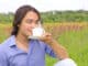 Portrait of young happy smiling man drinking coffee or tea outdoors