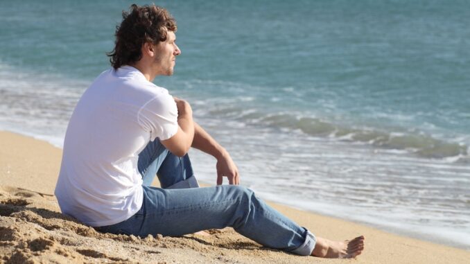 Man thinking and watching the sea on the beach