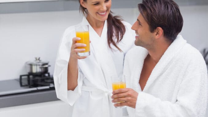 Couple drinking orange juice in the kitchen