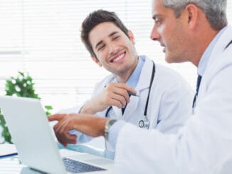Doctors talking together about something on their laptop in medical office