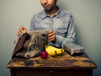 Man unpacking his lunch at an old desk