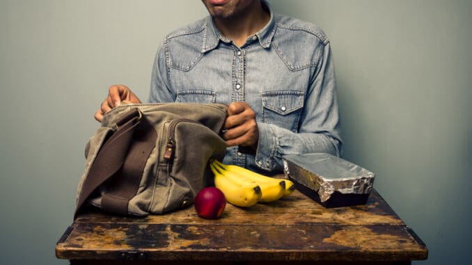 Man unpacking his lunch at an old desk