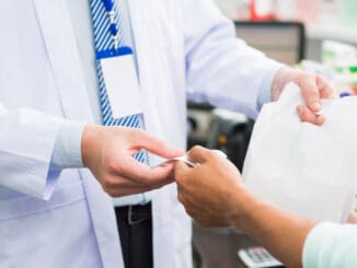 Cropped image of salesperson giving check and treatment in the drugstore on the foreground