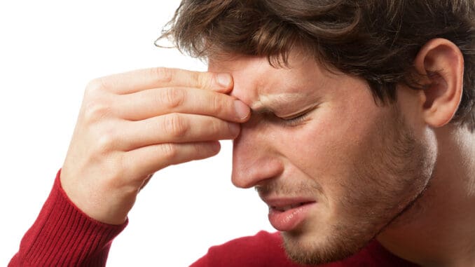 Man holding his nose because of a sinus pain