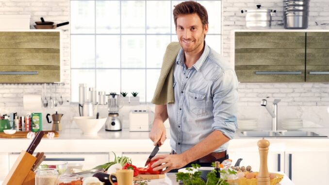 dreamstime_s_41082304 Happy handsome man cooking in kitchen at home.
