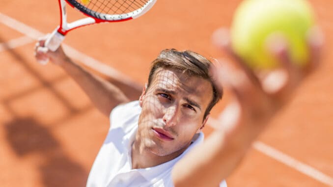 Young man playing tennis outdoors