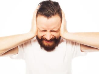 bearded man covering his ears by hands