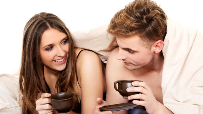 dreamstime_s_58894015 Young happy couple drinking coffee in bed.