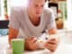 Man Eating Breakfast Whilst Checking Mobile Phone