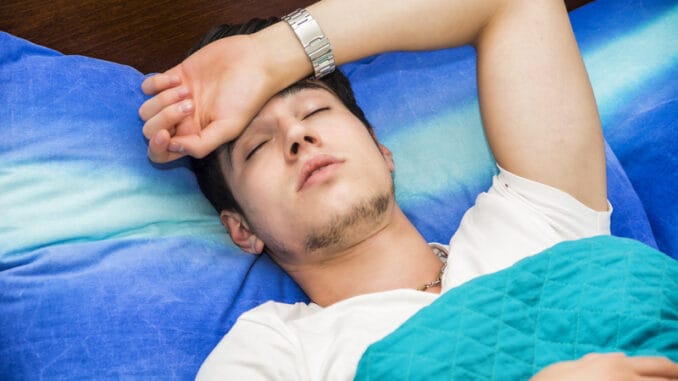 dreamstime_s_61035580 Young handsome sick or unwell man in bed