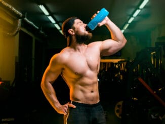 Man in the gym drinking from the shake