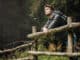 Young man with backpack hiking in the forest