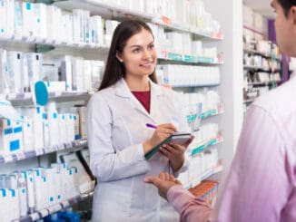 Helpful pharmacist serving and a consulting men in a pharmacy