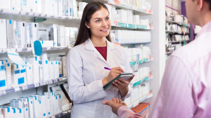 dreamstime_s_78057206 Helpful pharmacist serving and a consulting men in a pharmacy